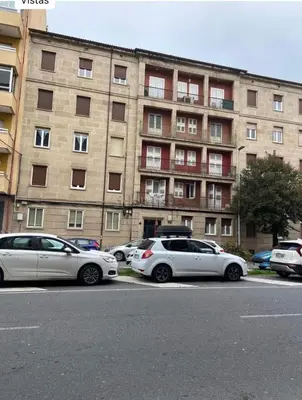 two cars parked in a parking lot in front of a building at Don Xesús in Ourense