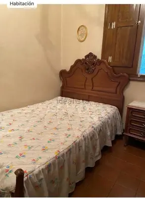 a bedroom with a large bed with a wooden headboard at Don Xesús in Ourense