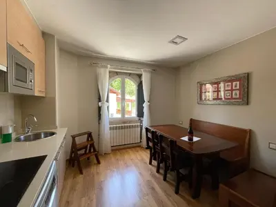 a kitchen and dining room with a table and chairs at Apartamentos Río Sil in Sober