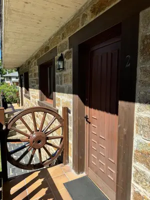 a wooden door and a wooden wheel next to a building at Apartamentos Sanabria in Galende