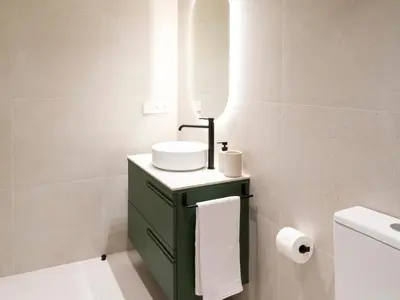 a bathroom with a green vanity with a sink and a mirror at Loft América 32-0 in Melide