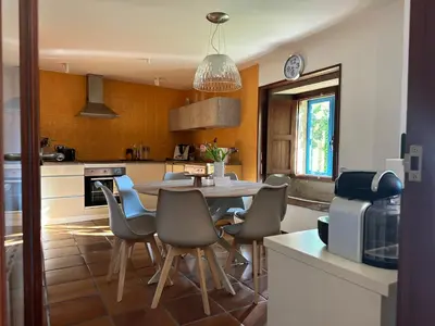 a kitchen with a table and chairs in it at Casa do Bidueiro in Luou
