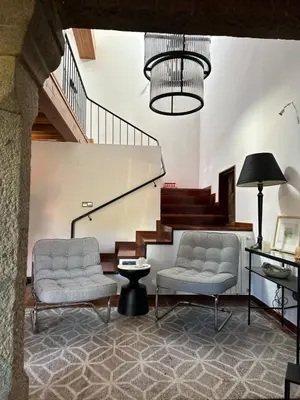 a living room with two chairs and a staircase at Casa do Bidueiro in Luou