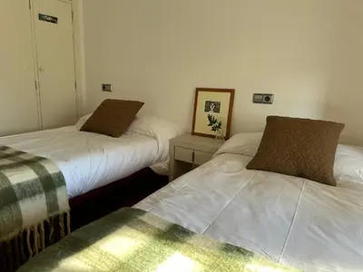 a room with two beds and a table with a picture at Casa do Bidueiro in Luou
