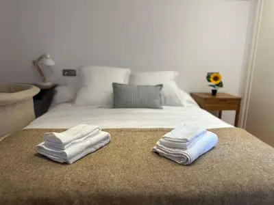 two folded towels are sitting on a bed at Casa do Bidueiro in Luou