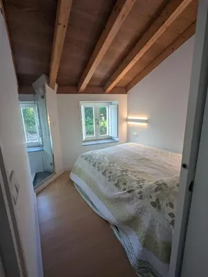 a bedroom with a bed and two windows at Casa Muralla in Ribadeo