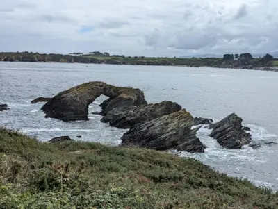 a group of rocks in the water near the ocean at Casa Muralla in Ribadeo