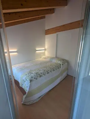 a bed in a room with a glass window at Casa Muralla in Ribadeo