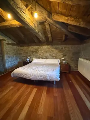 a bedroom with a bed in an attic at As Casias d'Oscos in Villanueva de Oscos