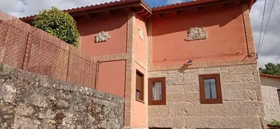 a house with a stone wall next to it at O Lar Do Bispo in Arbo