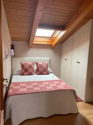 a bedroom with a large bed with pink pillows at O Lar Do Bispo in Arbo