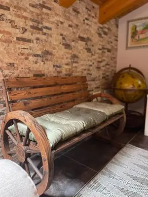 a wooden bench sitting next to a brick wall at O Lar Do Bispo in Arbo