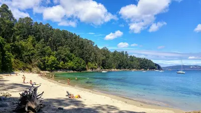 a group of people on a beach in the water at Casita con jardin en Sada in San Andrés de Carnoedo