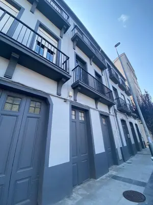 a building with blue doors on the side of it at Apartamento en Monforte in Monforte de Lemos