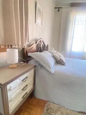a bedroom with a white bed and a lamp on a night stand at Apartamento en Monforte in Monforte de Lemos