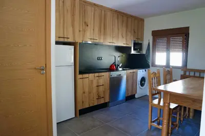 a kitchen with a white refrigerator and a table at Cainés in Villablino