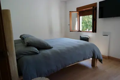 a bedroom with a bed with pillows and a window at Cainés in Villablino