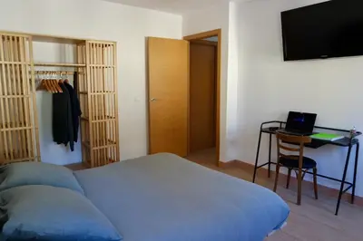 a bedroom with a bed and a television and a chair at Cainés in Villablino