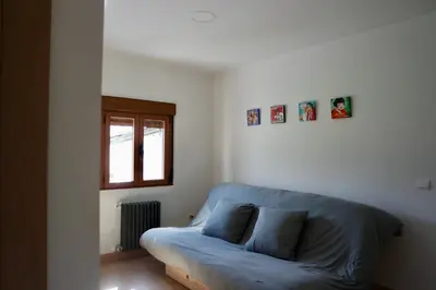 a blue couch in a room with a window at Cainés in Villablino