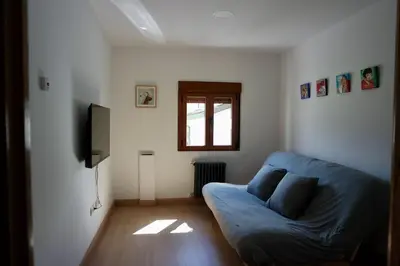 a living room with a blue couch and a window at Cainés in Villablino
