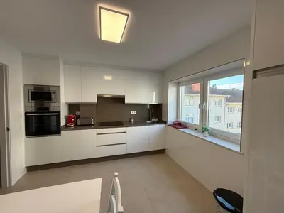 a kitchen with white cabinets and a large window at Casa Pilar segundo in Sigüeiro