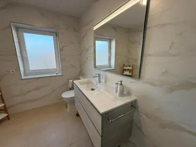 a bathroom with a sink and a toilet and a mirror at Casa Pilar segundo in Sigüeiro