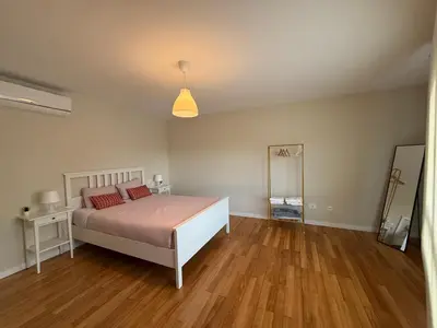 a bedroom with a bed and a window and wooden floors at Casa Pilar segundo in Sigüeiro