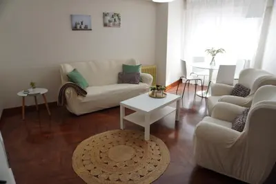 a living room with white couches and a table at O Ferrador in Caldas de Reis