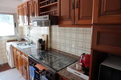 a kitchen with wooden cabinets and a counter top at O Ferrador in Caldas de Reis