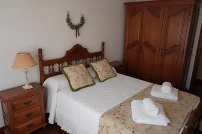 a bedroom with a bed with two towels on it at O Ferrador in Caldas de Reis
