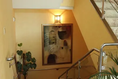 a staircase with a painting and a light on the wall at Hostal Tio Pepe II in Bembibre