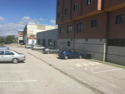 a parking lot with cars parked next to a building at Hostal Tio Pepe II in Bembibre