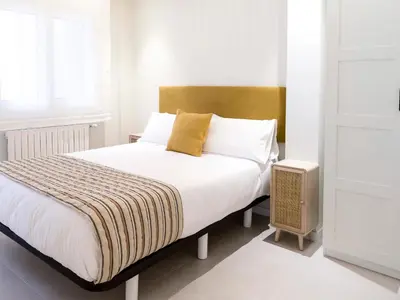 a bedroom with a bed with white sheets and yellow pillows at Loft América 32 in Melide