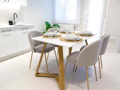 a white dining room with a white table and chairs at Loft América 32 in Melide