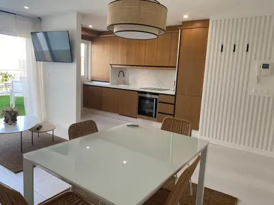 a kitchen with a white table and some chairs at A Terraza in Puentedeume