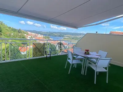 a table and chairs on a balcony with a view at A Terraza in Puentedeume