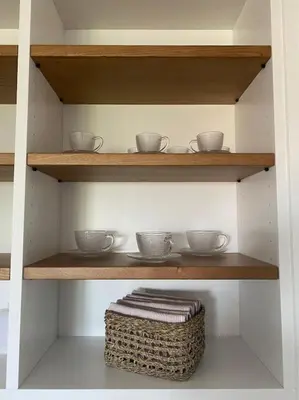 a shelf with bowls and plates and a basket at A Terraza in Puentedeume