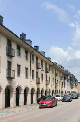 a red car parked in front of a large building at VUT Mencía in Ponferrada