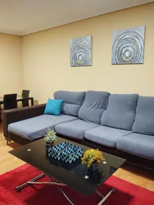 a living room with a blue couch and a table at VUT Mencía in Ponferrada