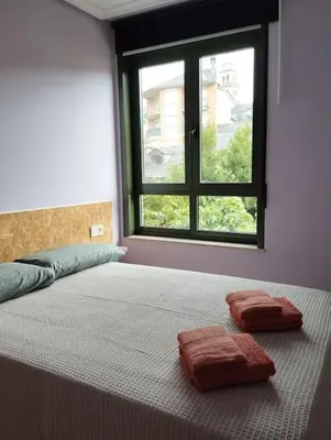 a bed with two towels on it in a room with a window at VUT Mencía in Ponferrada