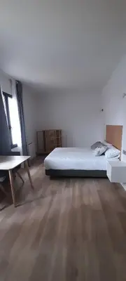 a white room with a bed and a wooden floor at Apartamentos Recunchos in Ourense