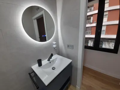 a bathroom with a white sink and a mirror at Apartamentos Recunchos in Ourense