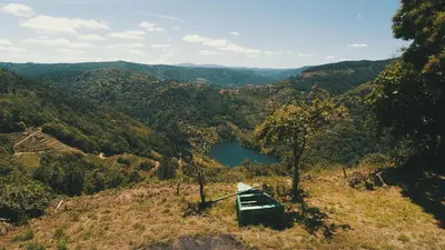 a boat sitting on top of a hill overlooking a lake at Geodesic Domes with Best Views in Ribeira Sacra in Pincelo