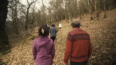 a group of people walking down a path in the woods at Geodesic Domes with Best Views in Ribeira Sacra in Pincelo