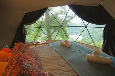 a bed in a room with a large window at Geodesic Domes with Best Views in Ribeira Sacra in Pincelo