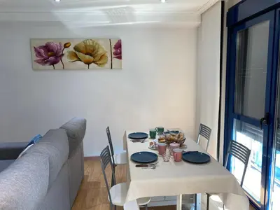 a table with chairs and a couch in a living room at A Ledicia no camiño in Melide
