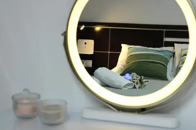 a mirror on a table with a bed in a room at A Ledicia no camiño in Melide