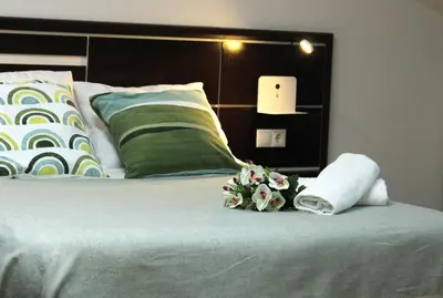 a bed with two towels and flowers on it at A Ledicia no camiño in Melide