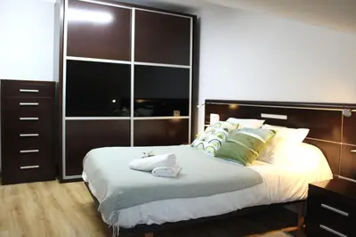 a bedroom with a large bed and a large closet at A Ledicia no camiño in Melide