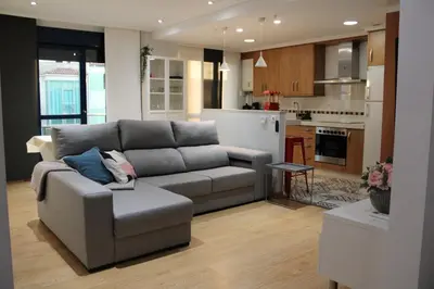 a living room with a couch and a kitchen at A Ledicia no camiño in Melide